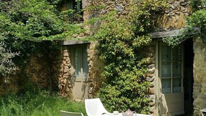 Een stenen gebouw met een kleine tuin, inclusief een tafel en stoelen.