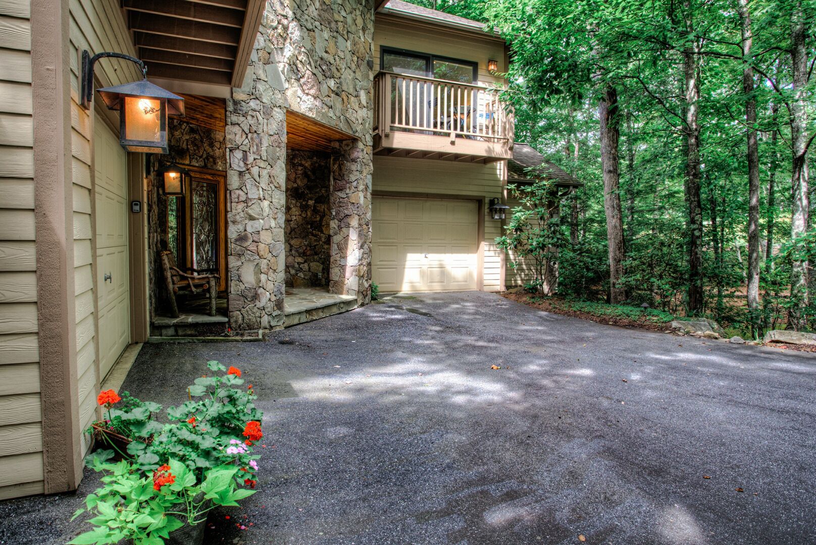A two-story house with a stone facade, a front porch, and a garage.