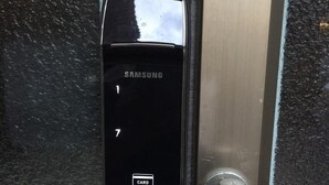Un lector de tarjetas Samsung instalado en una puerta, probablemente para control de acceso.