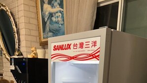 Un refrigerador con puerta de vidrio, dispensador de agua y estante.