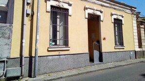 A yellow building with two windows, a door, and a small balcony. - B&b Scirocco d'Africa (Catania)