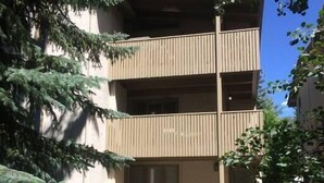 Edifici de tres pisos amb teulada plana i un balcó al segon pis.