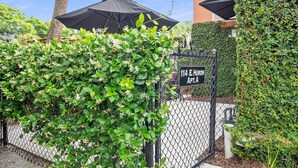 A gated entrance with a sign reading "114 E. Huron Apt. A".