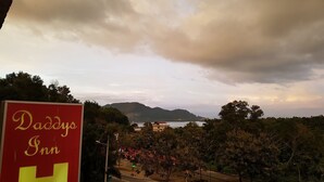A view of a hotel named 'Daddys Inn' with a prominent 'H' sign, surrounded by trees and a road with vehicles. - Daddy's Inn (Lumut)
