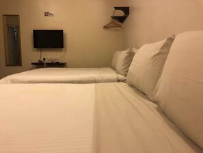 A twin bed with white bedding in a hotel room. - Daddy's Inn (Lumut)