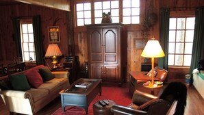 A cozy living room with a sofa, armchair, coffee table, and a lamp. - Beautiful Lake Burton Compound - Pet Friendly (Clarkesville)