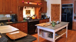 A kitchen with wooden cabinets, a central island, a stove, and a refrigerator. - Beautiful Lake Burton Compound - Pet Friendly (Clarkesville)