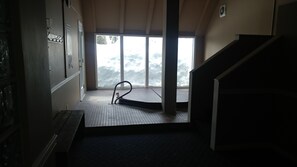 Enjoy breathtaking views of the snowy landscape from the comfort of this cozy room, featuring a tiled floor, bench, and staircase.