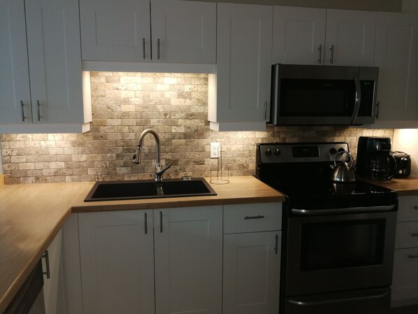Enjoy cooking in this well-equipped kitchen with a stove, coffee maker, and microwave.