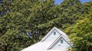 A two-story house with a front porch, a garage, and a staircase leading to the entrance. - A cabin with beautiful mountain views and outdoor lounge (Dunsmuir)