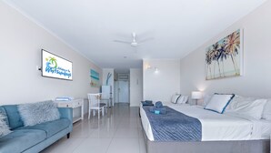A modern hotel room with a bed, a sofa, a desk, and a chair. - Ocean views 27A (Airlie Beach)
