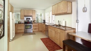 Una cocina moderna con armarios de madera, electrodomésticos de acero inoxidable y una isla grande con un fregadero.
