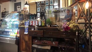 Ein Café mit einer Rocket-Espressomaschine, einer gekühlten Vitrine und einer Holztresen mit verschiedenen Artikeln.