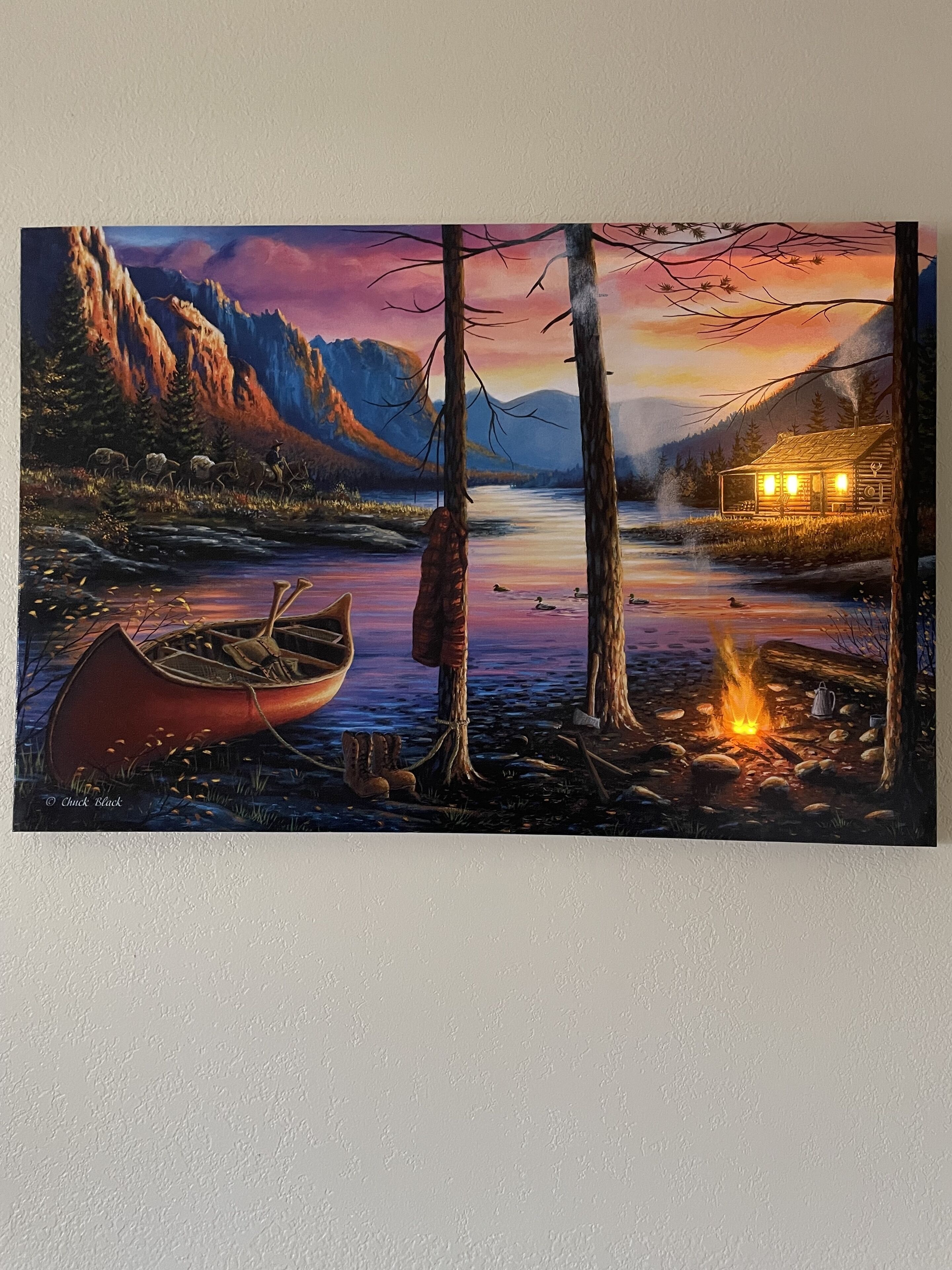 A cabin by a lake with a boat and a campfire.