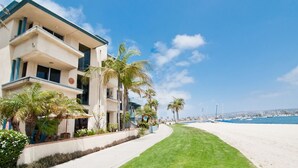 A beachfront hotel with a white sandy beach, palm trees, and a clear blue sky. - BAYFRONT! AUGUST 8 - 10 OPEN AMAZING VIEWS & LOCATION WALK TO FOOD, SHOPS, OCEAN (San Diego)