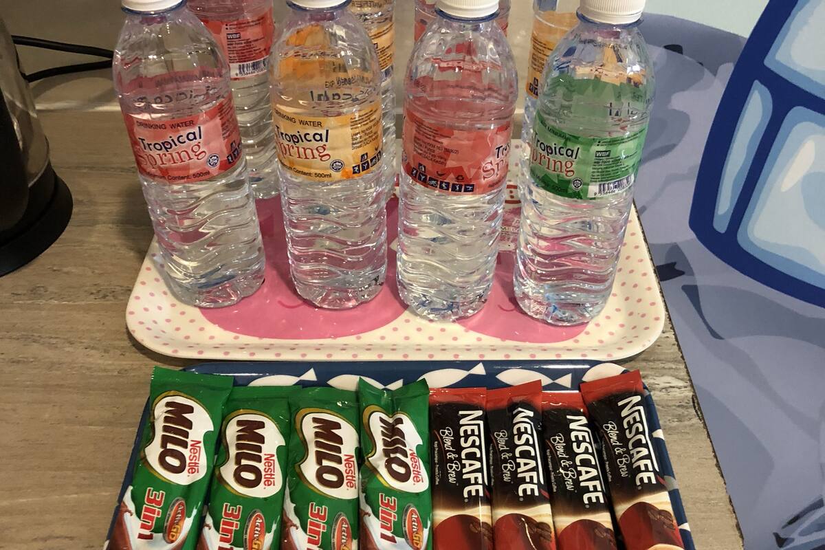 A table with bottled water and chocolate milk packets.