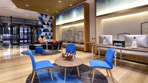 A modern hotel lobby with a reception desk, seating area, and Apple computers. - Holiday Inn Express Luanchuan by IHG (Luoyang)