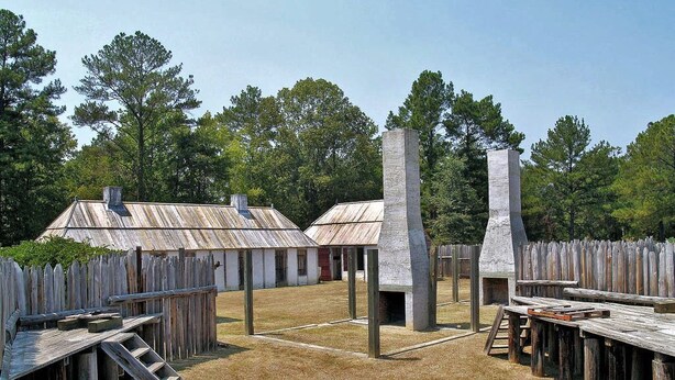 A rustic outdoor area with wooden structures, including a raised platform and benches, surrounded by a wooden fence. - Kayak Shak - Downtown Wetumpka (Wetumpka)