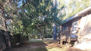 A grassy yard with trees and a wooden fence. - Kayak Shak - Downtown Wetumpka (Wetumpka)