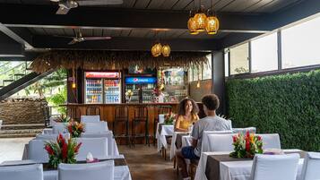 Un restaurante con terraza, zona de bar y vistas al verdor.