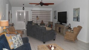 A living room with a sofa, chairs, a television, and a ceiling fan. - Salt Water Canal home w/Dock, Family/Pet Friendly, close to Beach and A1A (Palm Coast)