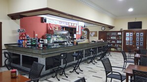A bar area with a counter, stools, and a menu board. - Hostal Restaurante el Lirio (Bollullos Par del Condado)