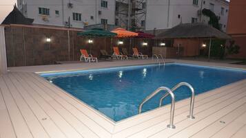 Una piscina al aire libre, sombrillas