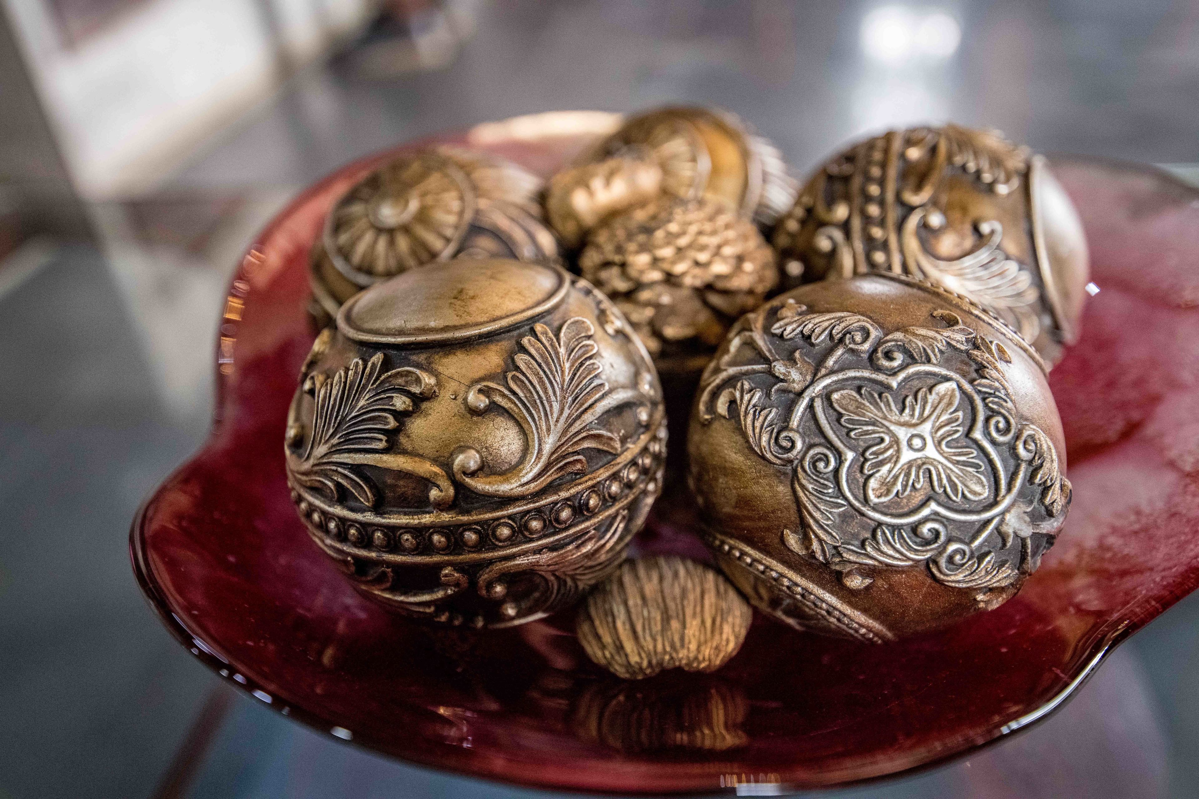A collection of intricately designed metal eggs on a reflective surface.