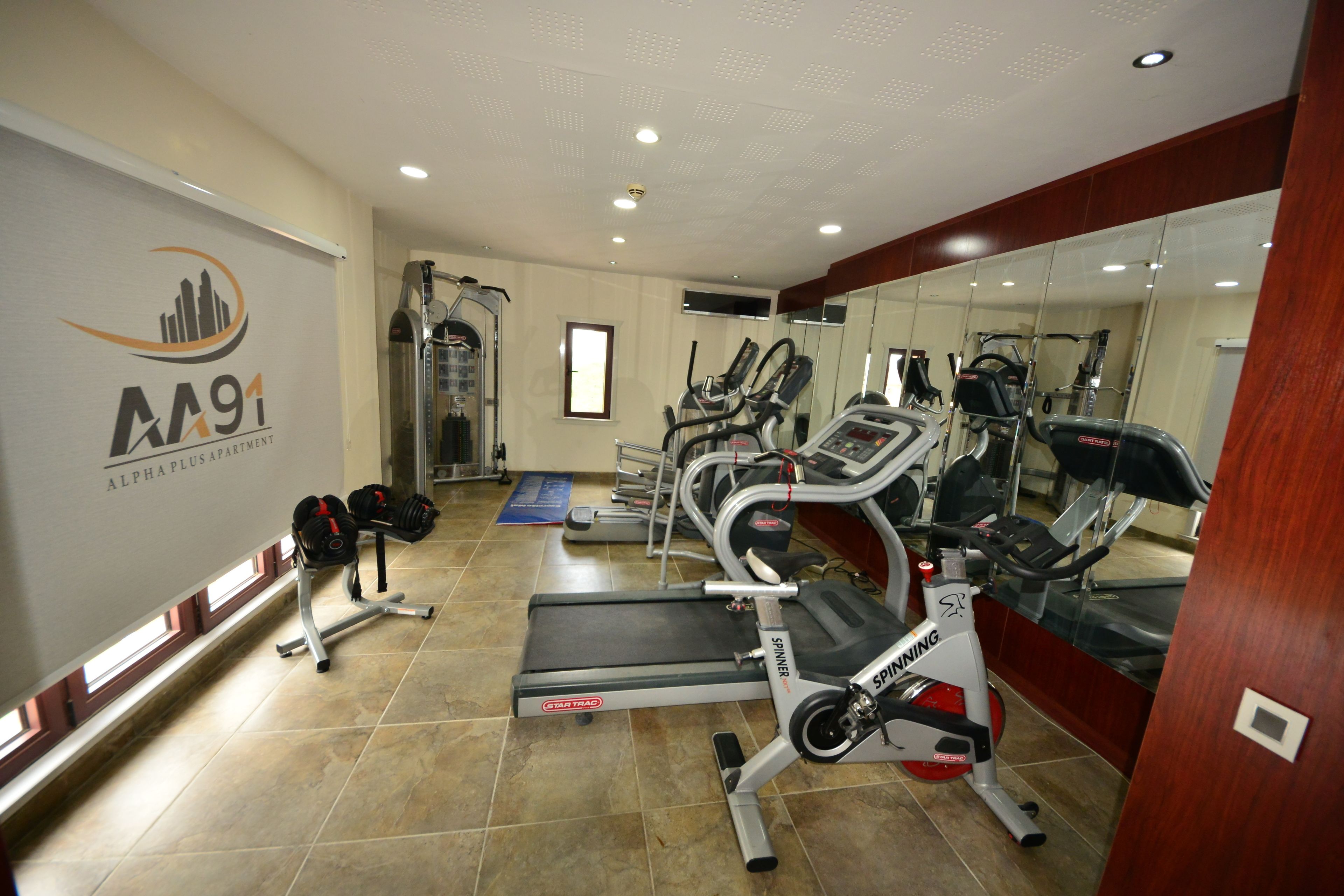 A gym with treadmills, elliptical machines, and weightlifting equipment.
