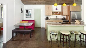 Une cuisine moderne dotée d’un îlot central, de meubles en bois et d’un réfrigérateur en acier inoxydable.