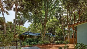 Il s’agit d’une propriété résidentielle dotée d’un jardin bien entretenu, d’un chemin menant à une maison avec un toit bleu et d’une clôture en bois qui entoure la propriété.