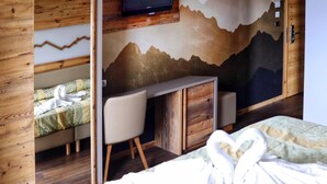 Ein Schlafzimmer mit einem Bett, einem Schreibtisch und einem Fernseher.