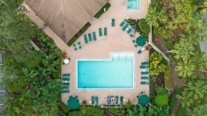 An aerial view of a resort with a large swimming pool, sun loungers, and a gazebo. - Luxury Beach Club- chairs, umbrellas, wifi, shelter included/ Pool, pickleball (Bonita Springs)