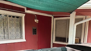 A hot tub with water flowing out, surrounded by a red building with windows and a green canopy. -  Holiday Hide Away  (Payson)