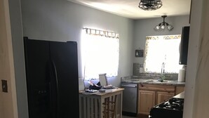 A kitchen with a refrigerator, stove, sink, and wooden flooring. -  Holiday Hide Away  (Payson)