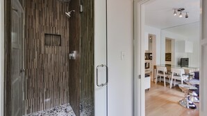 A modern bathroom with a shower, a glass door, and a tiled floor. - Beachcombers Hideaway, Dog Friendly, Enclosed Patio, 1 Block to Beach (La Jolla)
