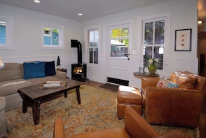 A living room with a sofa, a coffee table, a leather armchair, a fireplace, and a rug. - Historic Elk Ave Haven, Hot tub, Town of CB. (Crested Butte)