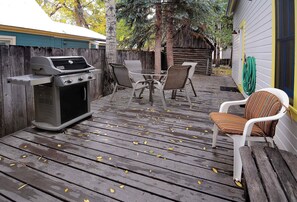 An outdoor deck with a grill, chairs, and a table. - Historic Elk Ave Haven, Hot tub, Town of CB. (Crested Butte)