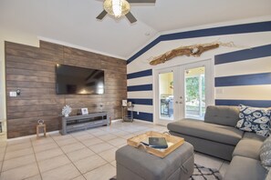 Relax in this stylish living room with a flat-screen TV, comfortable sofa, and a coffee table.