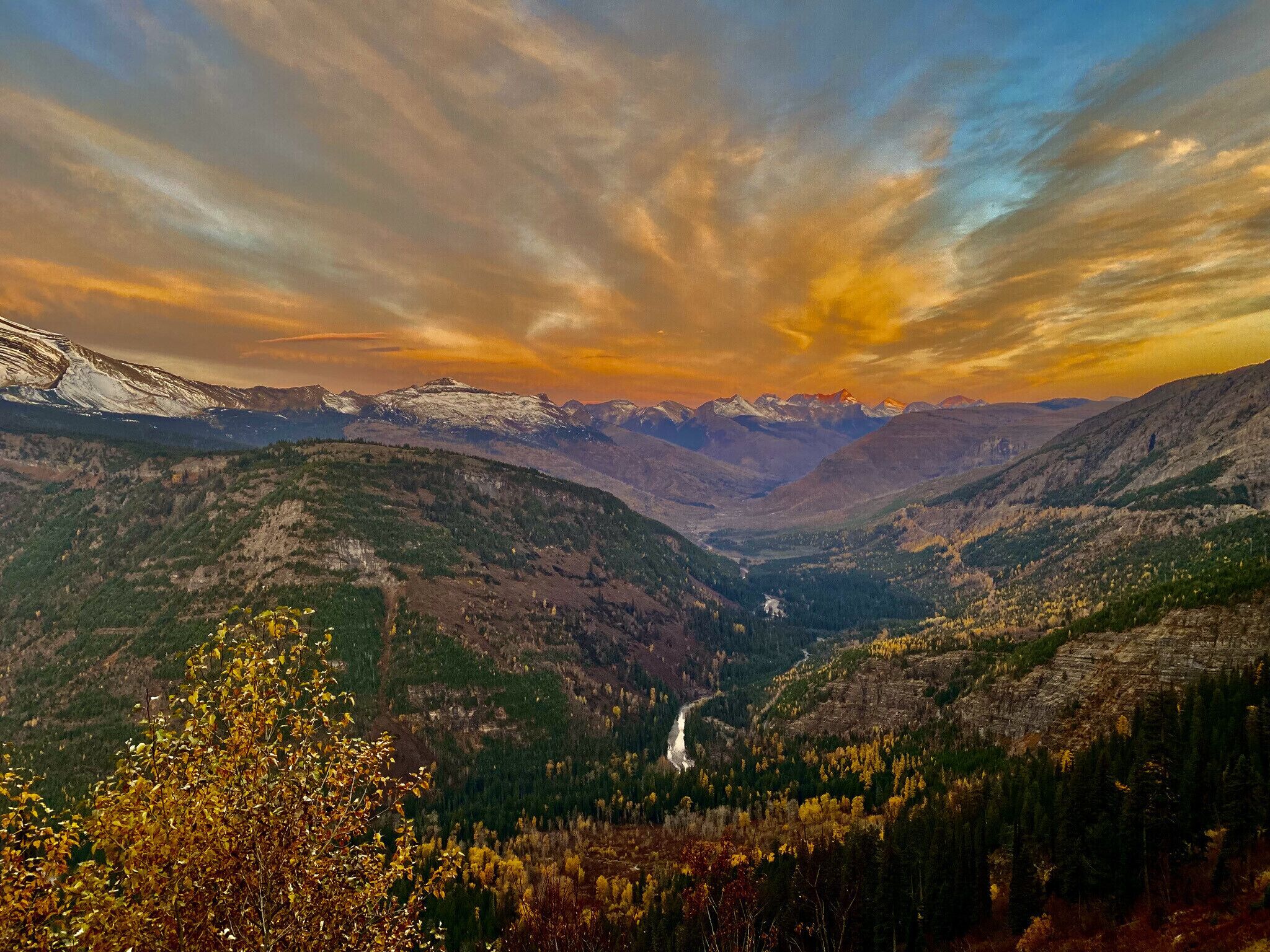 Un paisaje montañoso con un valle y un río.
