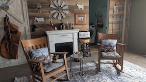 Una habitación rústica con chimenea, muebles de madera y un cartel de granja.