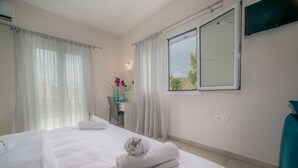 A hotel room with a bed, a desk, and a window. - Tesys Studios & Apartments (Zakynthos)