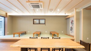 A conference room with a large wooden table and several benches.
