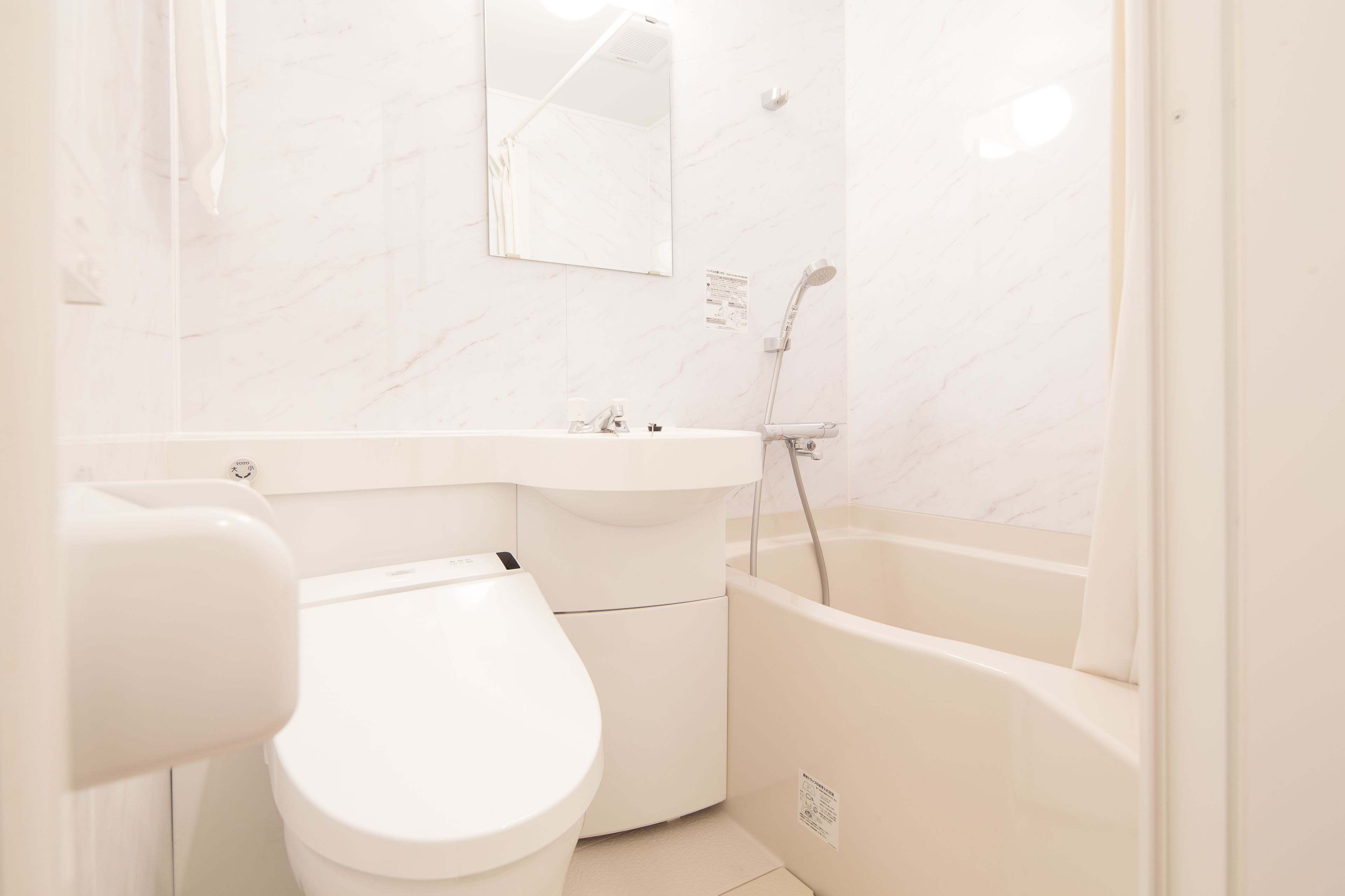 A modern bathroom with a toilet, sink, and bathtub.