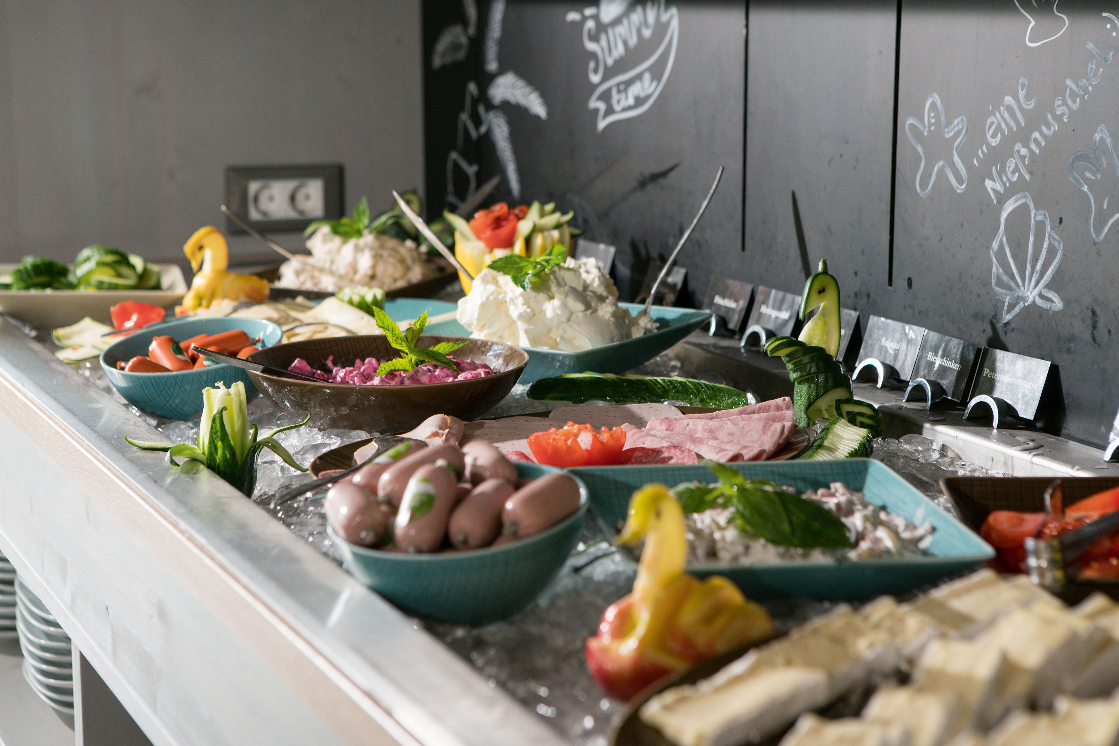 Un bufé con diversos platos, incluyendo mariscos, vegetales y postres.
