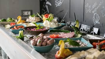 Un bufé con diversos platos, incluyendo mariscos, vegetales y postres.