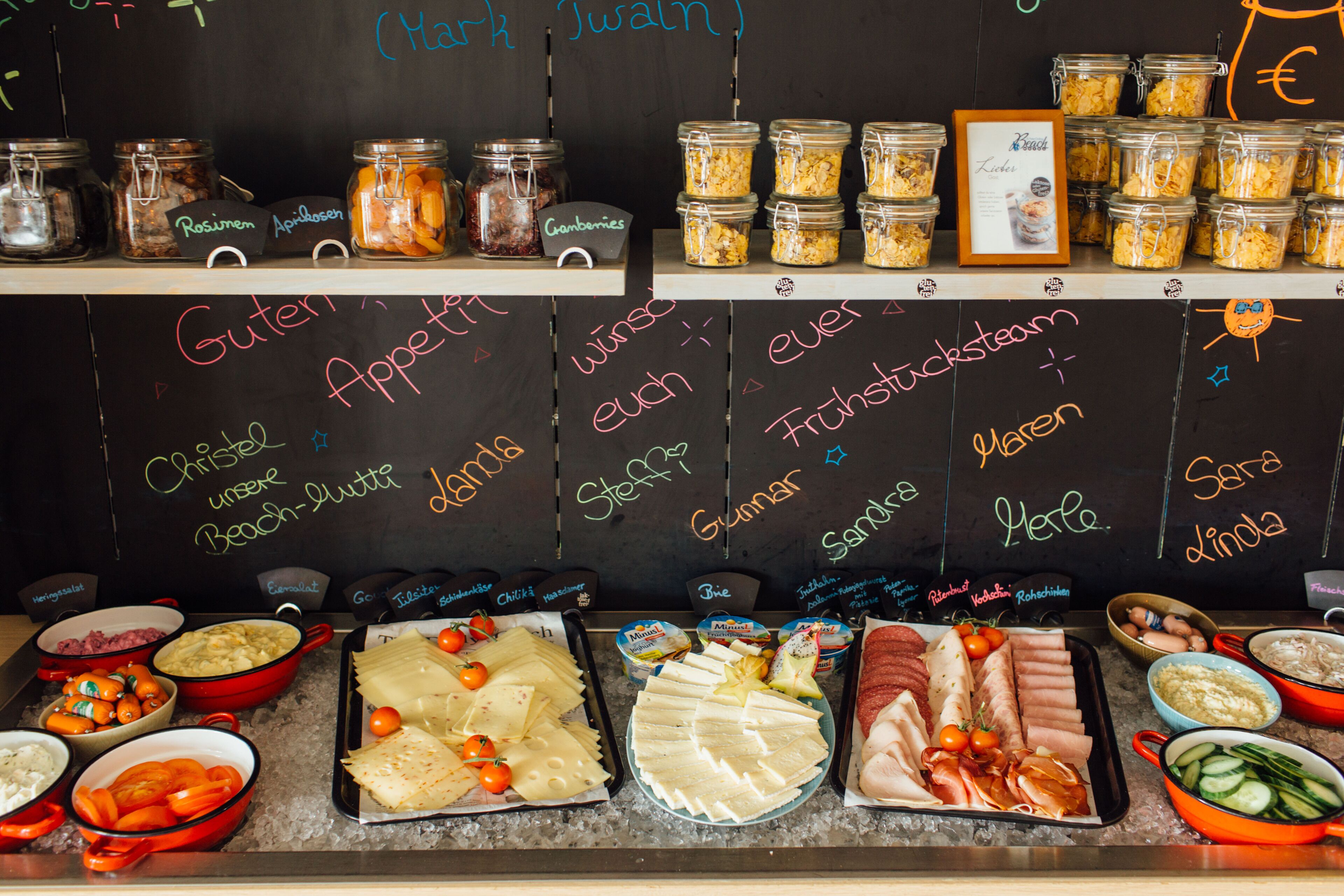 Un buffet proposant une variété de plats et un menu écrit à la craie.