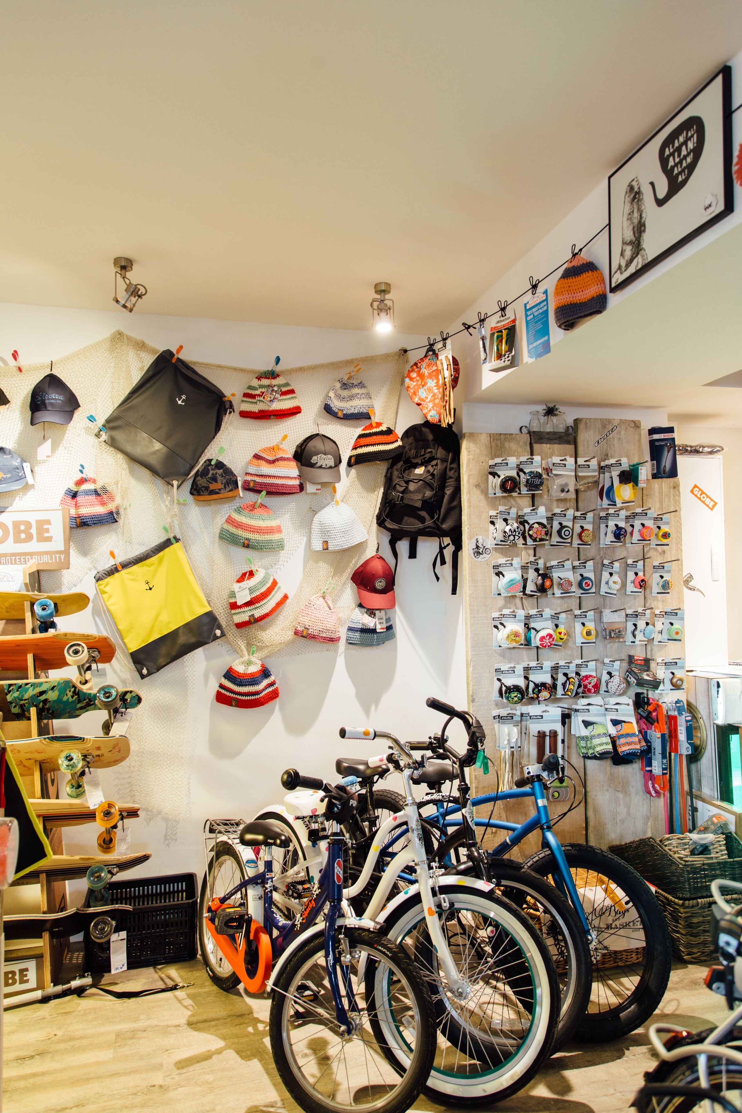 A store with bicycles, hats, and bags on display.