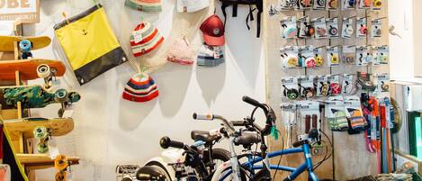 A store with bicycles, hats, and bags on display.