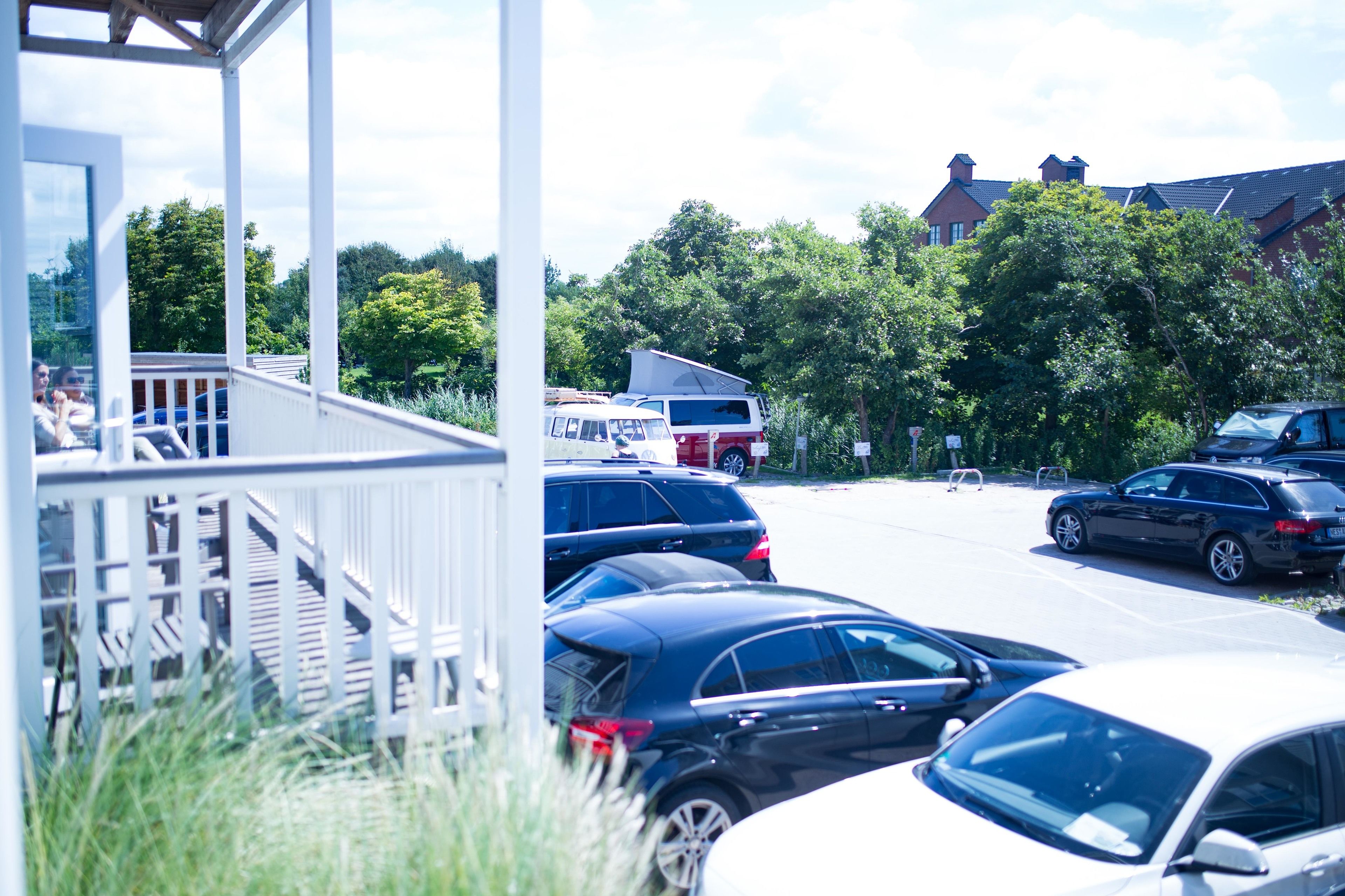 Ein Parkplatz mit mehreren Autos und einem überdachten Gang.
